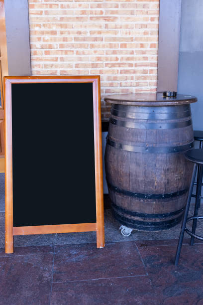 istock large wooden barrel used as a table and empty black restaurant menu advertising board on the outside of a restaurant 1395606655