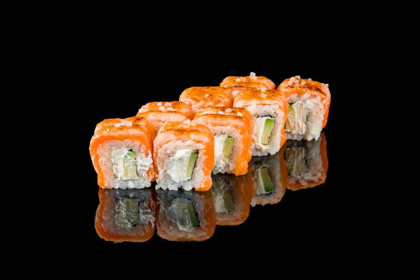 istock roll with baked salmon and avocado on black with reflection 1395608904