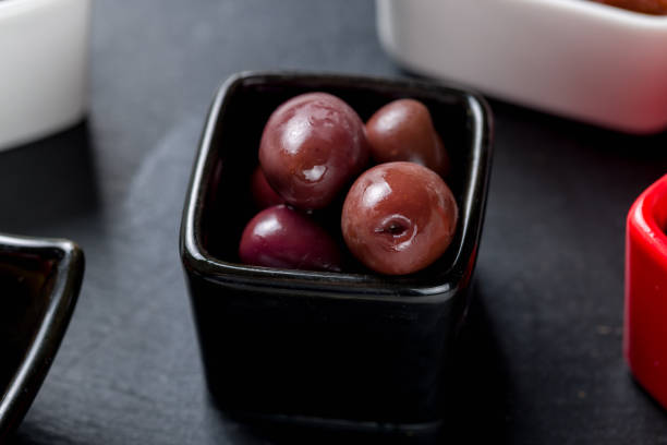 istock Kalamata olives on dark stone plate macro close up 1395609031