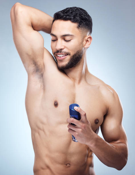 istock Shot of a young man applying deodorant against a studio background 1395615067