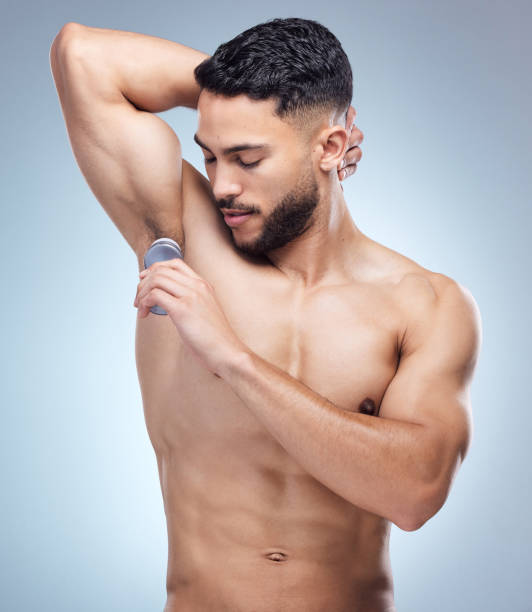 istock Shot of a young man applying deodorant against a studio background 1395615073