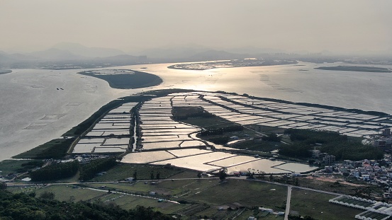 Aquaculture farm by the sea in the distance