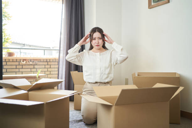 istock Asian women having trouble packing for moving 1395630116