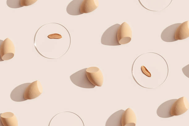 istock Makeup sponges for foundation cream, samples on glass disk on beige color background with shadows. Skincare beauty blender. Flat lay swatches from tone cream and sponge, aesthetic trends 1395634474