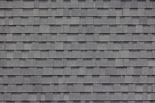 decoración de tejas asfálticas gris oscuro en la pared o el techo de la casa. decoración de tejas asfálticas gris oscuro en la pared o el techo de la casa. photo