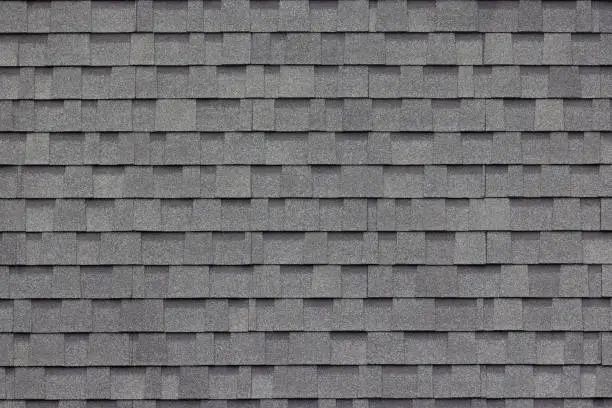 Photo of dark grey asphalt tiles decoration on house wall or roof. dark grey asphalt tiles decoration on house wall or roof.