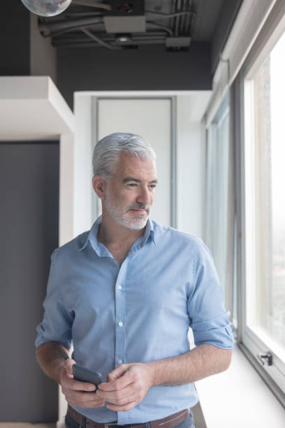 istock Young middle-aged professional near window at office 1395640997