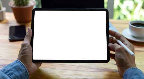 istock mock up empty screen tablet, businessman working on his tablet with blank space screen for advertising text on wood desk in office 1395646260