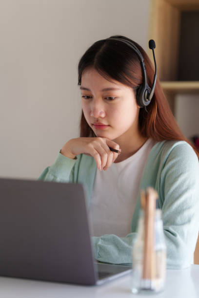 istock E-learning ,online ,education and internet social distancing protect from COVID-19 viruses concept. Asian woman student video conference e-learning with teacher on laptop computer at home. 1395646412