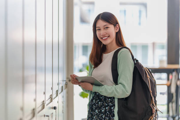 istock Young college student with backpack at class room. E-learning Online Education concept. 1395647173
