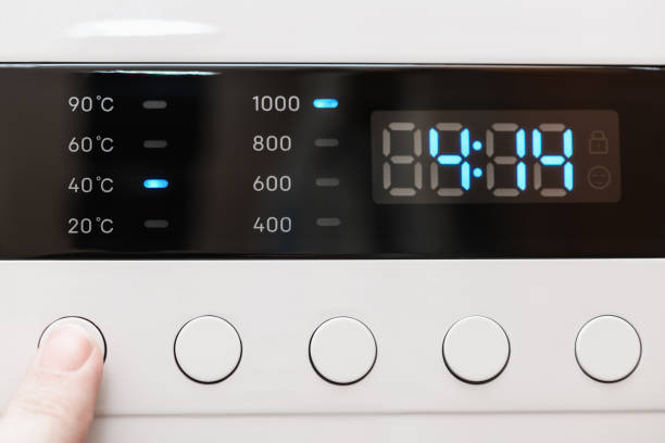 istock Washing machine display close up ,time remaining four hour 14 minutes during washing process. Finger selects wash mode. Abstract laundry programming backdrop 1395649239