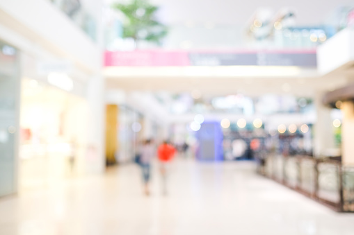 Woman in mid 30s goes shopping for denim jeans in a mall or a clothing store.