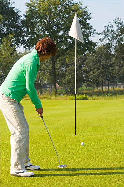 istock Senior golfer putting on a golf green 139565187