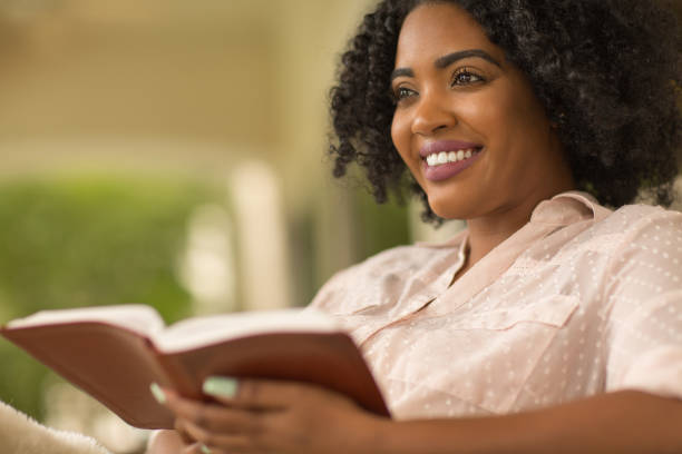 istock Woman smiling holding a book. 1395653265