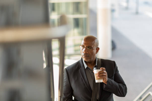 istock African American businessman walking and drinking coffee. 1395654168