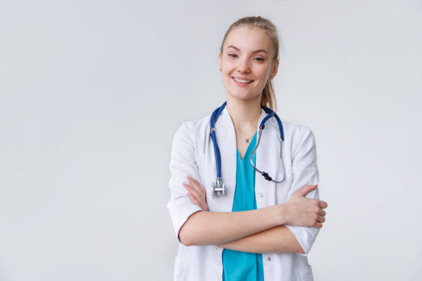 POrtrait of young caucasian woman therapist in uniform with stethoscope standing with crossed arms stock photo