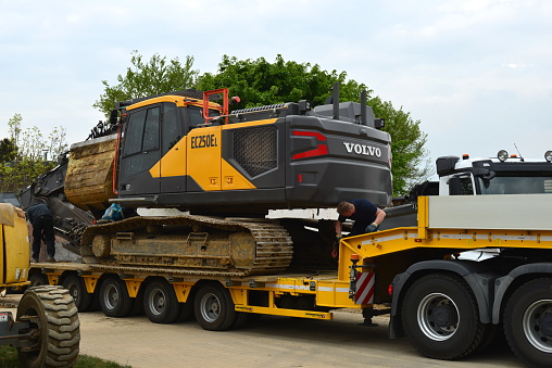 Wilsele, Vlaams-Brabant, Belgium - May 05, 2022: demolished building constructions and cleaned up terrain. Follow up work in progress. Next is building new apartment complex. Vehicles earthworks ready to leave the site. Volvo EC 250 EL loaded on a truck trailer