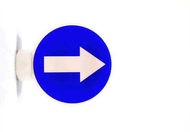 Traffic sign with a white arrow on a blue background indicating a mandatory direction to the right