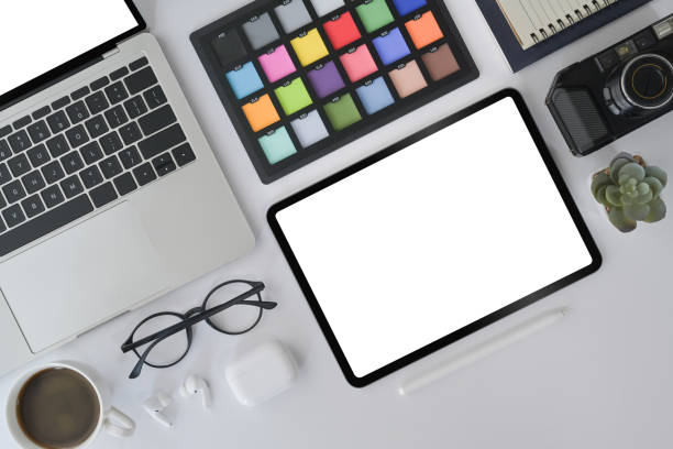 istock Creative designer workplace with digital tablet, laptop, camera and color swatch on white office desk. 1395668449
