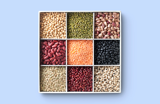 Various colorful dried legumes isolated on blue background.