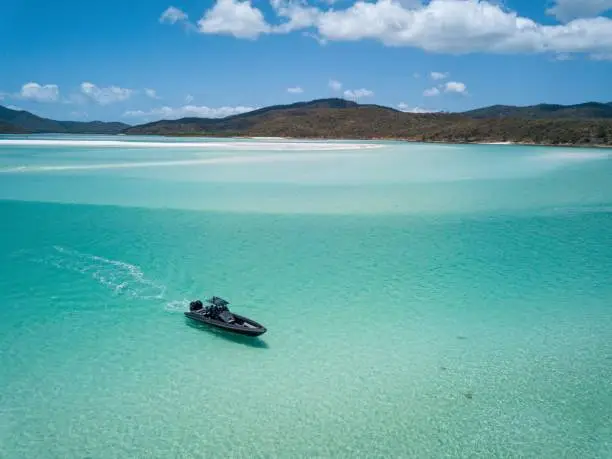 Rigid inflatable black  boat at Whitehaven Beach,