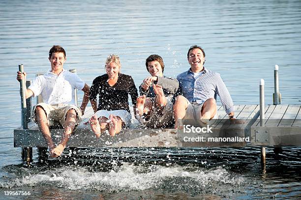 Happy Family Having Fun Playing In Water With Their Feet Stock Photo - Download Image Now
