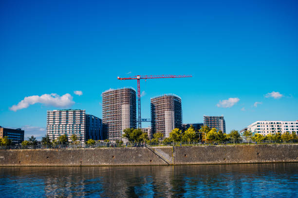 istock Construction site with cranes by the river Main in Frankfurt, clear sky above 1395678367