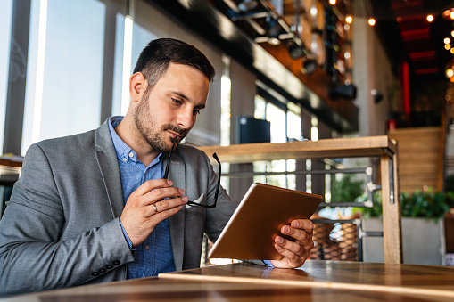 Portrait of young business man working online on digital tablet. Business people technology concept