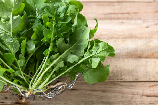 istock Fresh Arugula leaf on wood background. 1395680814
