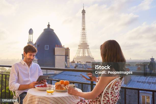 Shot Of A Young Couple Having Breakfast On The Balcony Of An Apartment Overlooking The Eiffel Tower In Paris France Stock Photo - Download Image Now
