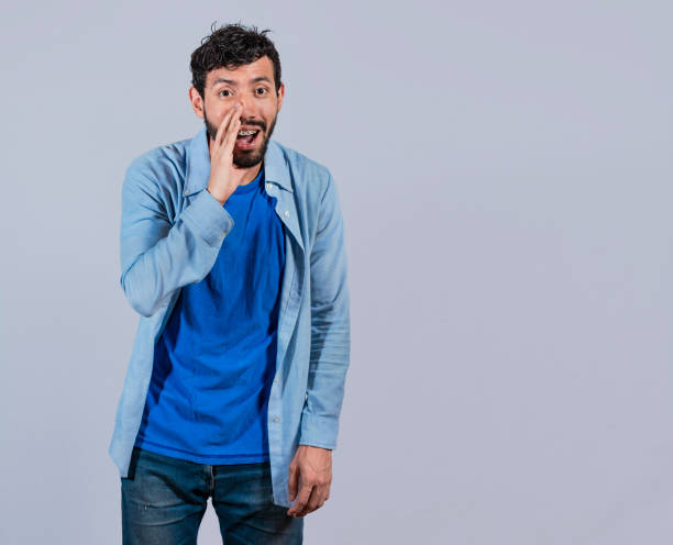 istock Man announcing with a whisper, man speaking discreetly to the camera, man speaking with a whisper to you 1395681894