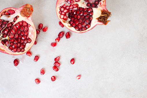 Pomegranate split open with pips on a grunge surface with copy space
