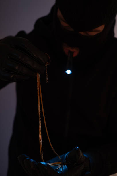 istock Burglar stealing gold jewelry. 1395683753