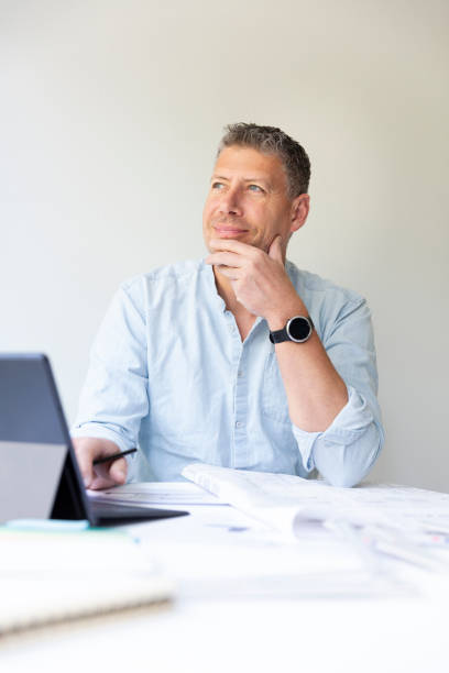 istock Business portrait of architect sitting at his work table and planning 1395684813
