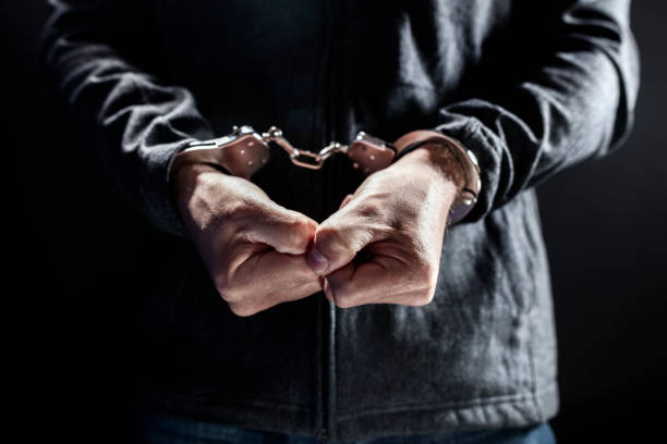 istock Criminal wearing handcuffs in prison 1395684992