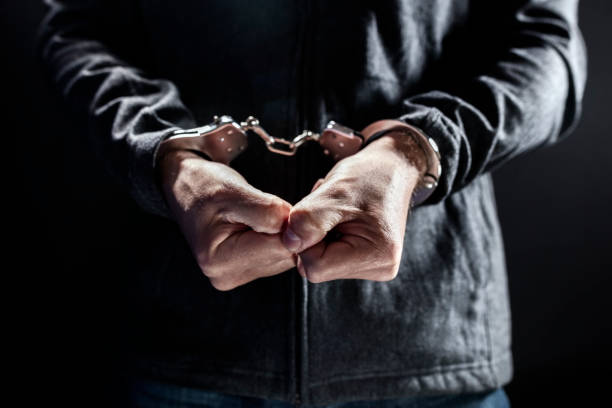 Criminal wearing handcuffs in prison stock photo