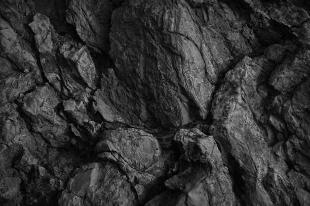 istock Black white rock texture. Rough mountain surface. Close-up. Dark volumetric stone background with space for design. 1395685236