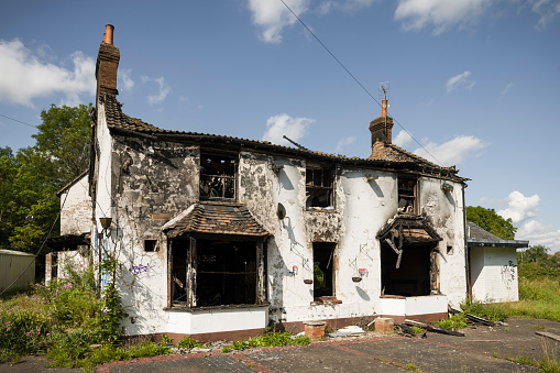 Buckinghamshire, UK - August 10, 2021. Fire damaged house. Building with burnt down roof and blackened walls.