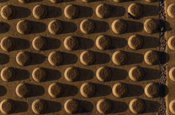 Grooved tiles anti-slip strips of footpath. Cones truncated background texture.