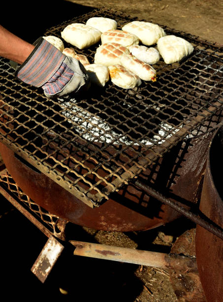Traditional South African roosterkoek or bannock being grilled on an open fire