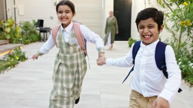 Laughing Saudi schoolchildren arriving home from school