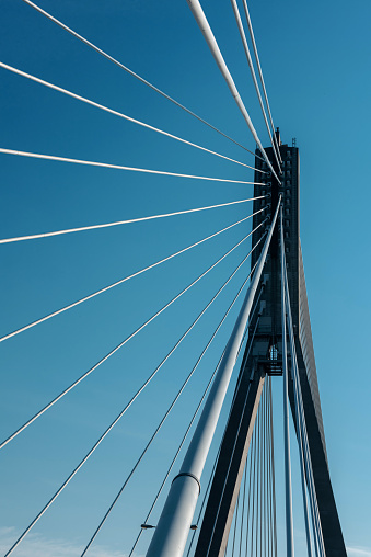 Bridge support with cables on sky background.