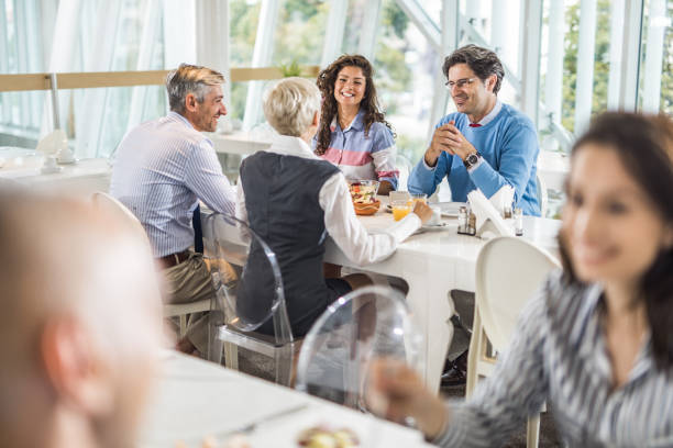 istock Happy business colleagues talking on a lunch break in cafeteria. 1395692461