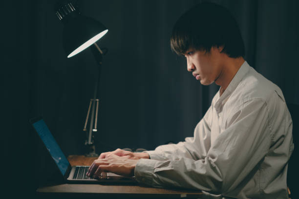 istock man typing with laptop under the lamp 1395693385
