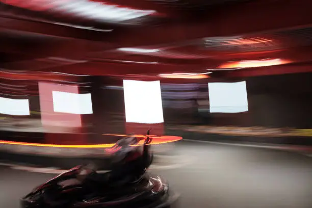 Blurred Electric Go kart driver speed rive indoor circuit race