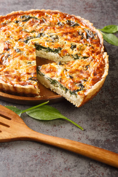 istock French Florentine quiche with spinach, cheese and egg custard close-up. vertical 1395693773