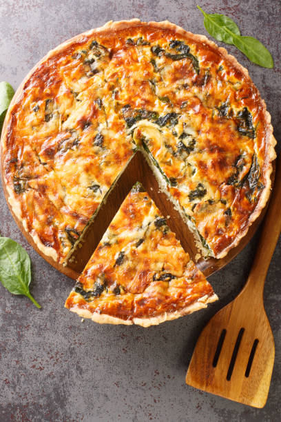 istock French Florentine quiche with spinach, cheese and egg custard close-up. vertical top view 1395693800