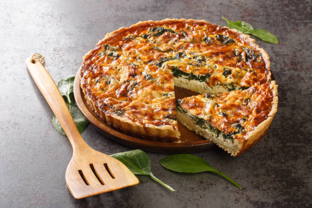 savory tart of rich egg custard, spinach and cheese with cut out a slice on the plate close-up. hotizontal - hotizontal imagens e fotografias de stock