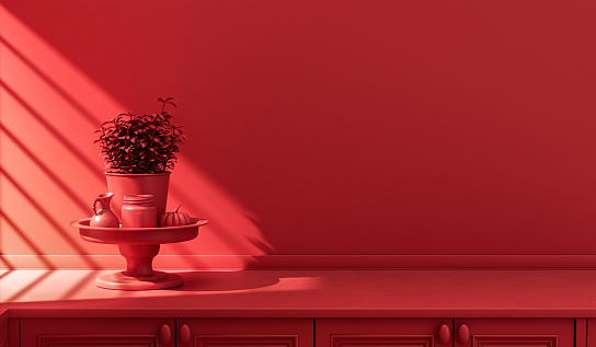 Stylized single color red kitchen counter and everyday utensils in morning sunlight.