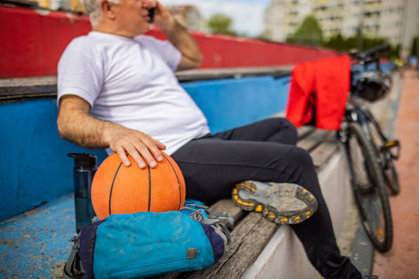 istock Senior man, taking a break from basketball game while talking on mobile phone 1395694702